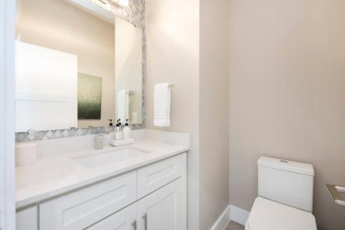 a white bathroom with a sink and a toilet at Mahogany Villa 2-A / 4BR in Omega Gardens