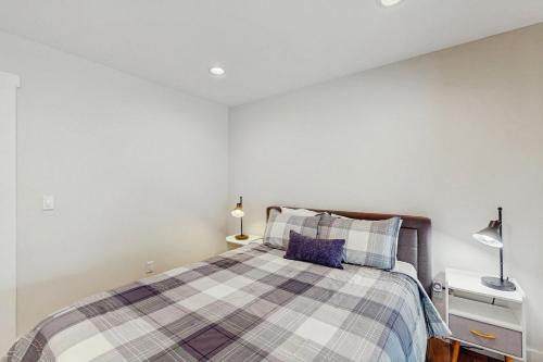 a bedroom with a bed with a plaid blanket at Lukk Enn in Trinidad