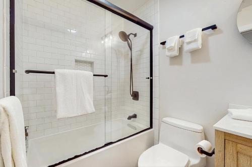a white bathroom with a shower and a toilet at Lukk Enn in Trinidad