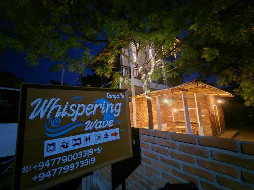 a sign in front of a house at night at Whispering Wave Tangalle in Tangalle