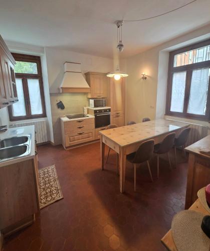 a kitchen with a table and chairs in a room at Appartamento 110mq Zona Terme posto auto privato in Bormio