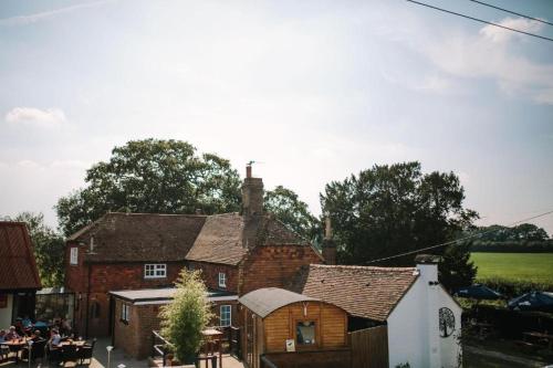 an old brick house with people sitting outside of it at The George and Dragon Pub in Shipley