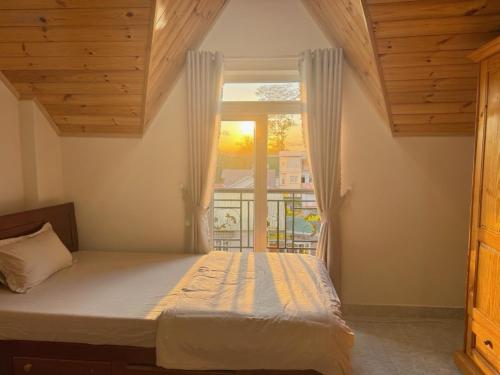 a bedroom with a bed and a window at Kha Phat Central Dalat with Local Charm in Xuan An