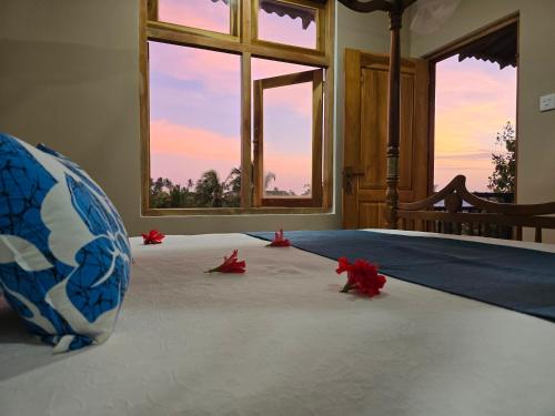 a room with a vase and red flowers on the floor at Whispering Wave Tangalle in Tangalle