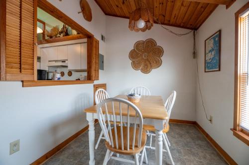 a kitchen and dining room with a wooden table and chairs at Dune View TB3E - Cozy 1BR Condo with Loft, Pool, Pet-Friendly in Kill Devil Hills