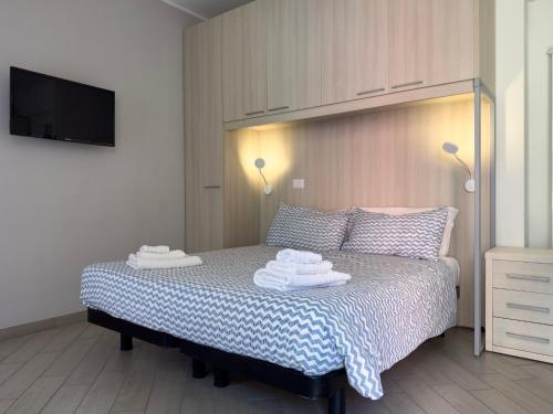 a bedroom with a bed with towels on it at BelSorrisoVarese - Elegance City Residence Private Parking -Reservation Required- in Varese