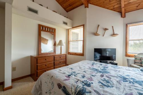 a bedroom with a bed and a dresser and a television at Dune View TB3E - Cozy 1BR Condo with Loft, Pool, Pet-Friendly in Kill Devil Hills