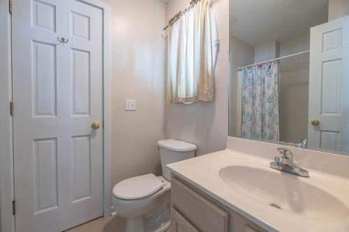 a white bathroom with a toilet and a sink at D0597 Dune Fine - Duck Landing Amenities, Pool, Hot Tub, Pets OK, Keyless! in Duck