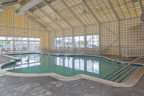 a large indoor swimming pool in a building at D0597 Dune Fine - Duck Landing Amenities, Pool, Hot Tub, Pets OK, Keyless! in Duck
