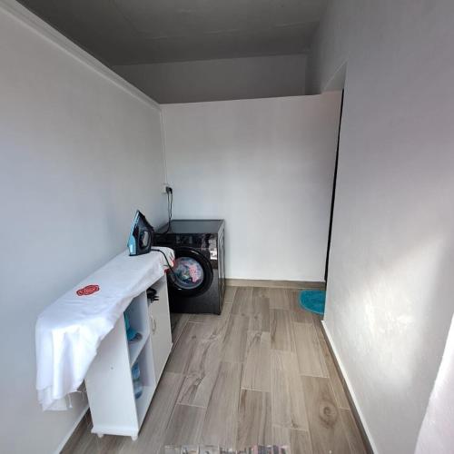 a small room with a table and a washing machine at villa atomium in Midlands Station
