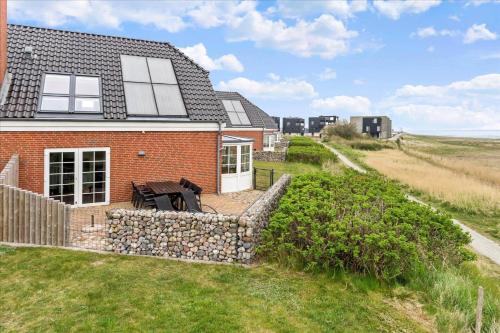 a red brick house with a stone retaining wall at 0286-Romo-Sonder-Frankel-34 in Havneby