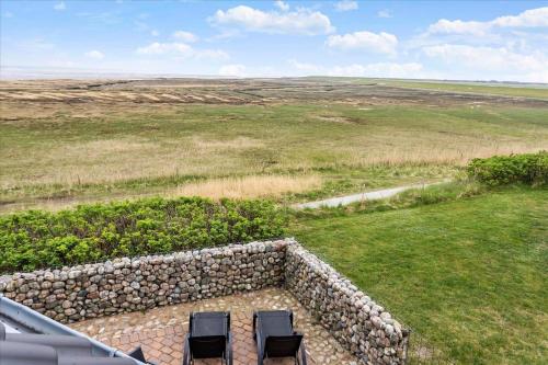 two chairs and a stone wall in a field at 0286-Romo-Sonder-Frankel-34 in Havneby