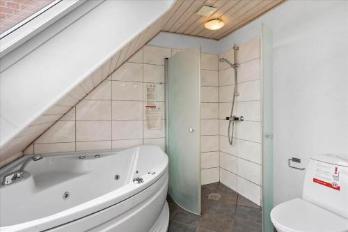 a bathroom with a bath tub and a toilet at 0286-Romo-Sonder-Frankel-34 in Havneby