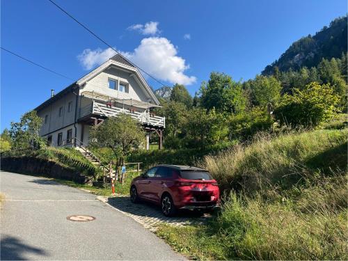 a red car parked in front of a house at Ferienwohnung Storck in Bad Bleiberg