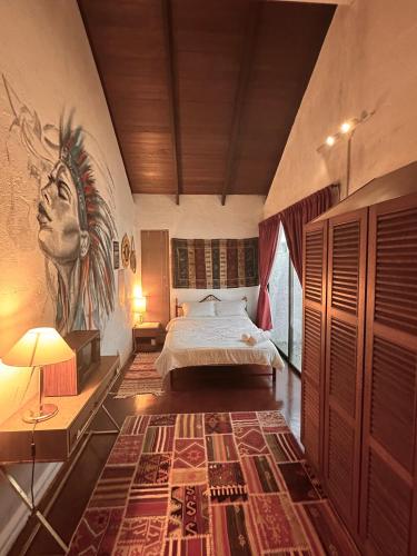 a bedroom with a bed and a painting on the wall at The White Horse, Private Pool, Sauna and Valley View in Cameron Highlands