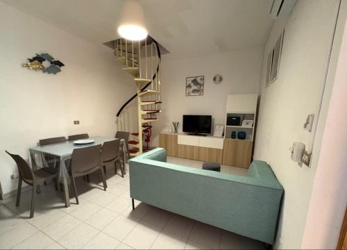 a living room with a table and a dining room at Casa vacanze con terrazza in Ginosa Marina