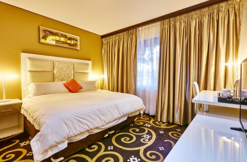 Habitación de hotel con cama y ventana en Palm Continental Hotel en Johannesburgo
