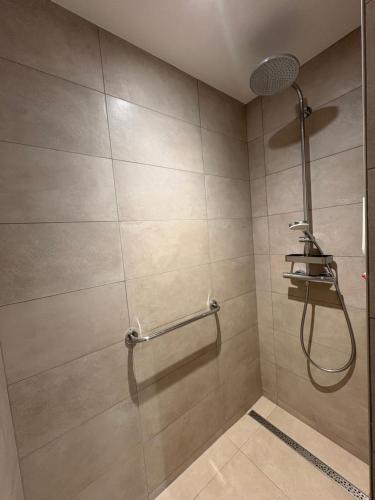 eine Dusche mit Duschkopf in einem Badezimmer in der Unterkunft La maison près de la fontaine B&B paisible 1 in Lépanges-sur-Vologne