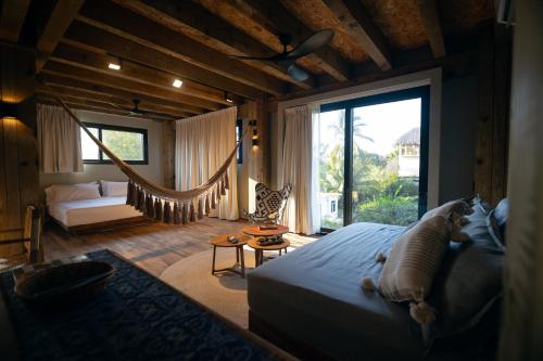 a bedroom with a bed and a hammock in a room at Kineki 8 in Brisas de Zicatela
