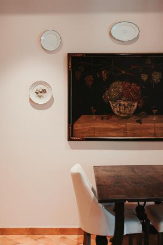 a dining room with a table and a painting on the wall at Rondaia, a Winery & Fincahotel-Agroturismo in Tramuntana in Esporles