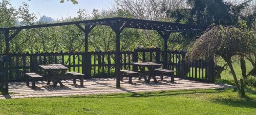 a picnic table and benches under a pergola at Fattoria Roico Funny Ranch in Montiglio