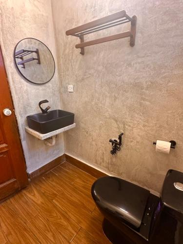 a bathroom with a black toilet and a sink at The White Horse, Private Pool, Sauna and Valley View in Cameron Highlands