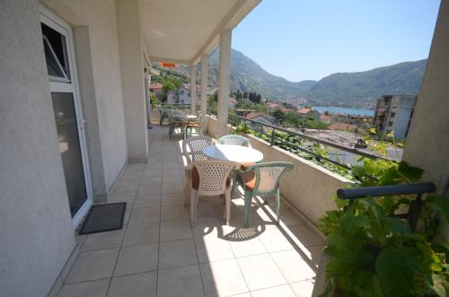 a balcony with tables and chairs and a view at Apartments Dakovic in Kotor