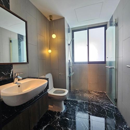 a bathroom with a sink and a toilet and a mirror at Black Martini Premium Suite in Tanjong Tokong