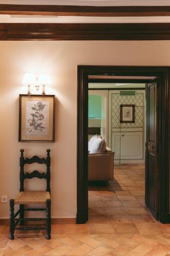 a chair sitting in a room with a bedroom at Rondaia, a Winery & Fincahotel-Agroturismo in Tramuntana in Esporles