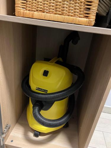a yellow vacuum cleaner sitting on a shelf at Domek na Morenowym Wzgórzu, nad jeziorem in Mierzyn