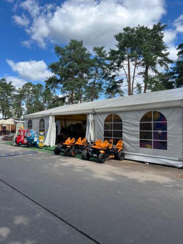 a white tent with a row of kayaks in it at Domek na Morenowym Wzgórzu, nad jeziorem in Mierzyn