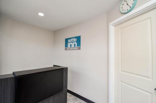a door in a room with a tv and a clock at Settle Inn in Sioux Falls