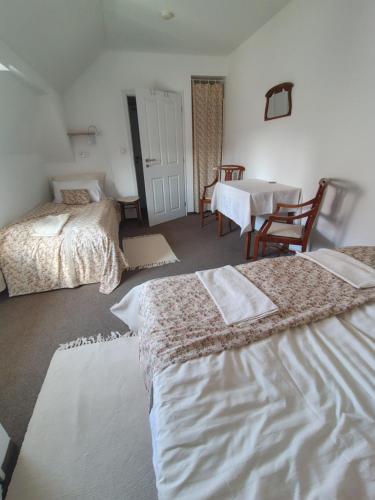 a hotel room with two beds and a table and a dining room at Penzion Nad Kašnou in Kašperské Hory