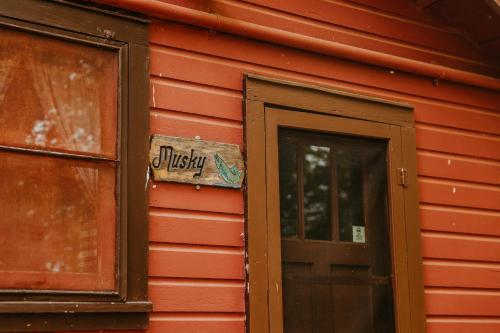 a sign on the side of a red house with a door at Old Stoney's Musky - Big Arbor Vitae Lake in Arbor Vitae
