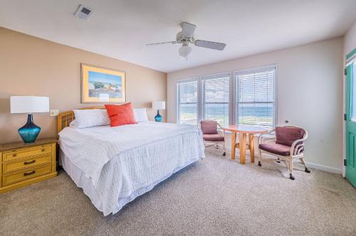 a bedroom with a bed and a table and chairs at K0013 Dunes for Days - Spectacular Oceanfront, Hot Tub & Rec Room! Pets OK! in Nags Head