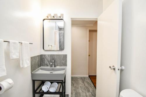 a white bathroom with a sink and a mirror at Settle Inn in Sioux Falls