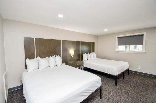 a hotel room with two beds and a window at Settle Inn in Sioux Falls