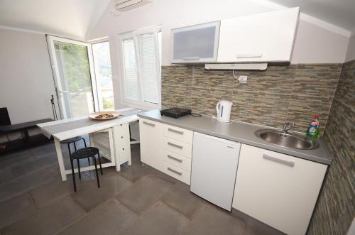 a kitchen with white cabinets and a sink and a counter at Apartments Dakovic in Kotor