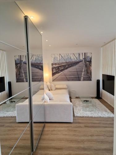 a bedroom with a white bed and a bridge painting on the wall at Ferienwohnungen Fuchs in Duisburg