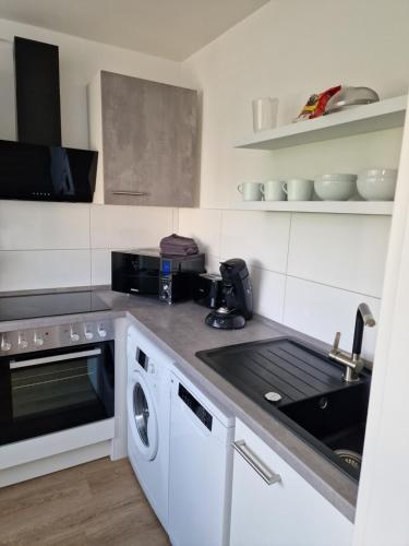a kitchen with a sink and a stove top oven at Ferienwohnungen Fuchs in Duisburg