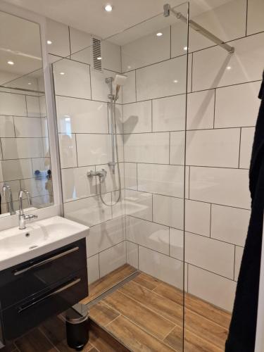 a bathroom with a shower and a sink and a mirror at Ferienwohnungen Fuchs in Duisburg