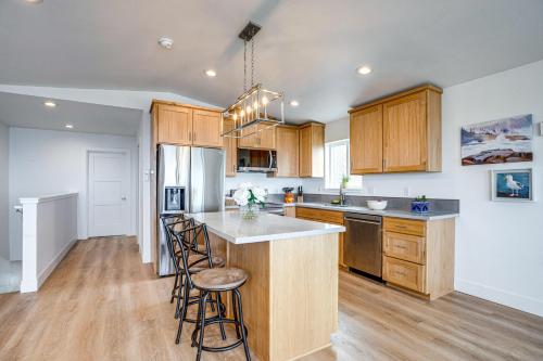 a kitchen with wooden cabinets and a island with bar stools at Walk to Beach WFH-Friendly Retreat in Tillamook! in Tillamook