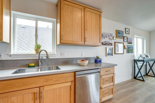 a kitchen with wooden cabinets and a stainless steel sink at Walk to Beach WFH-Friendly Retreat in Tillamook! in Tillamook