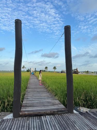 a little girl walking on a wooden bridge over a field at MI LE GARDEN Chalet in Sekincan