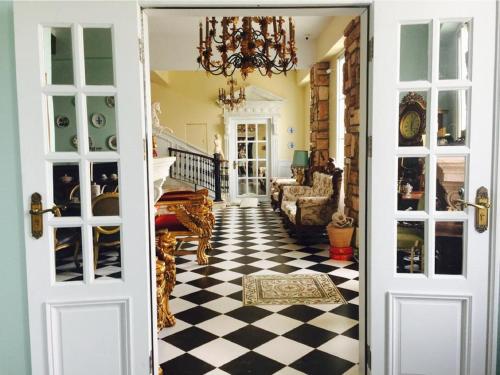 a hallway with a door open to a room with a checkered floor at 法國小古堡-Chateau de France in Wujie