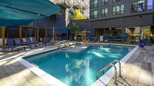 ein großes Schwimmbad mit Stühlen und einem Gebäude in der Unterkunft Luxury 1BR Atlanta Apartment in Atlanta