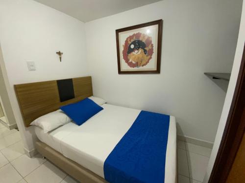 a bed in a bedroom with a picture on the wall at Amoblados Medellín Laureles in Medellín