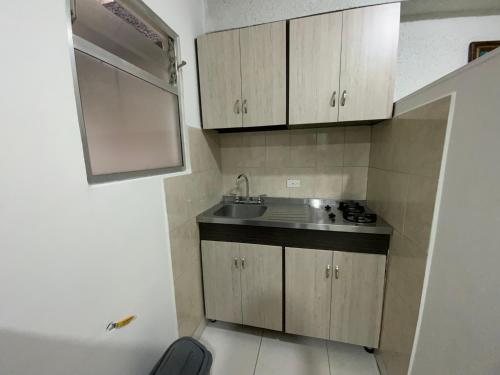 a small kitchen with a sink and a counter at Amoblados Medellín Laureles in Medellín