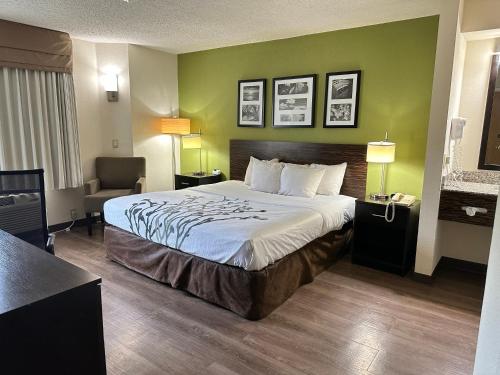 a hotel room with a bed and a chair at Sleep Inn & Suites Near Columbus - State University Area in Columbus