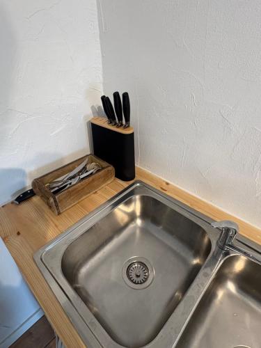 a kitchen sink with a knife block next to it at Gäststugan in Ystad